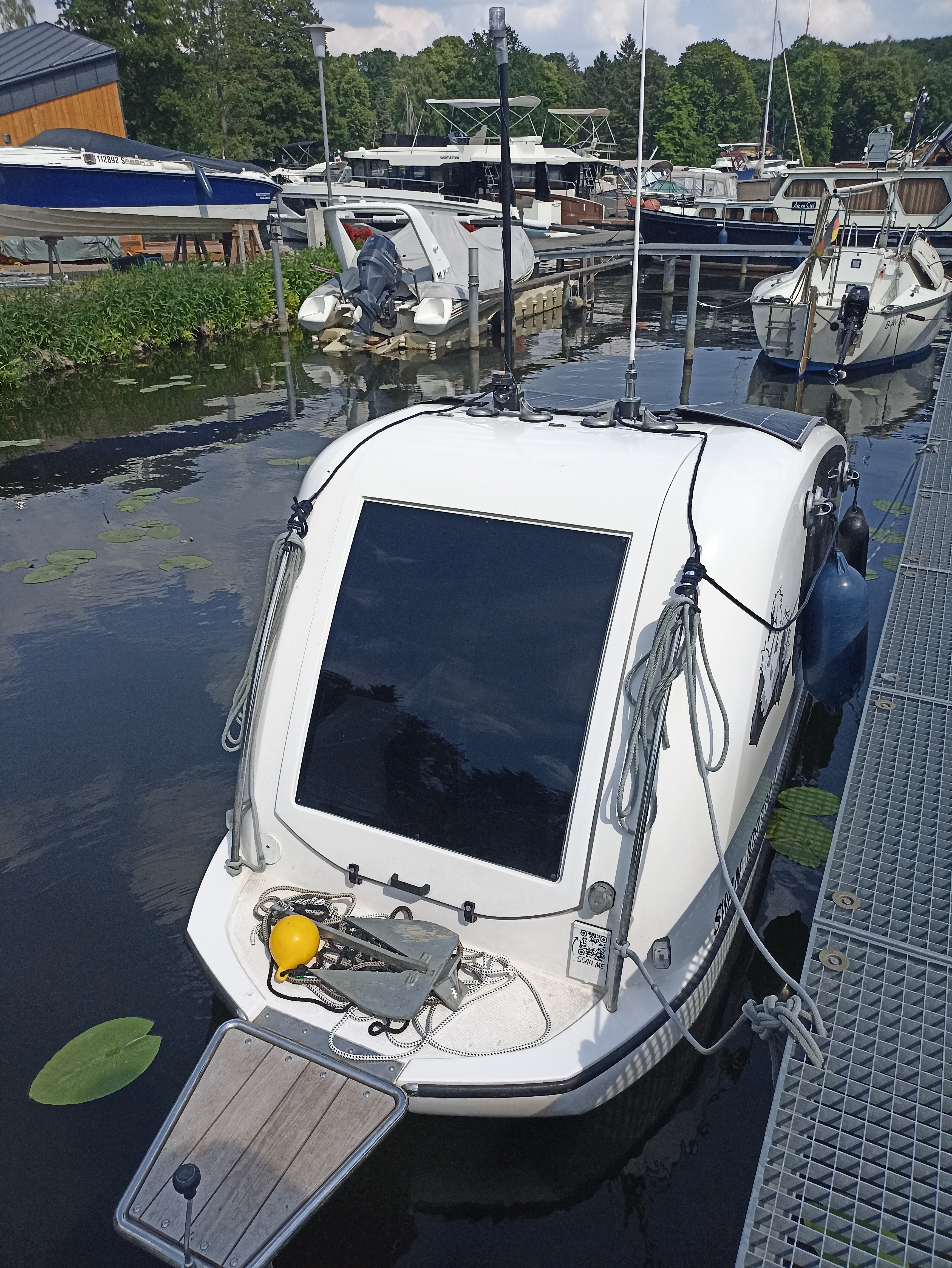 Es handelt sich um einen Boot-Wohnwagen der im Hafen am Steg festgemacht ist